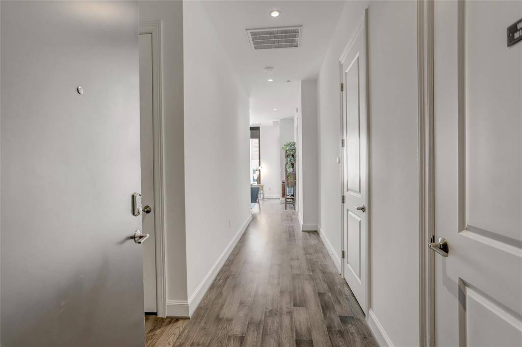 A welcoming view from the entrance, this long foyer leads into the open living space, highlighted by stunning floor-to-ceiling windows that fill the home with natural light.