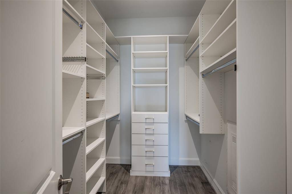 The walk-in closet is a masterpiece of design, featuring custom-built cabinetry by Spaceman Company. With thoughtful organization in mind, it offers ample storage space for your wardrobe, including hanging areas, shelves, and drawers. The high-quality craftsmanship ensures both functionality and a polished, modern look.