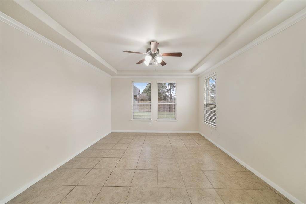 Spacious primary bedroom with a tray ceiling.