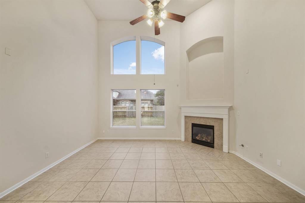 The living room with tall, gorgeous windows that have solar screens to help with energy efficiency.