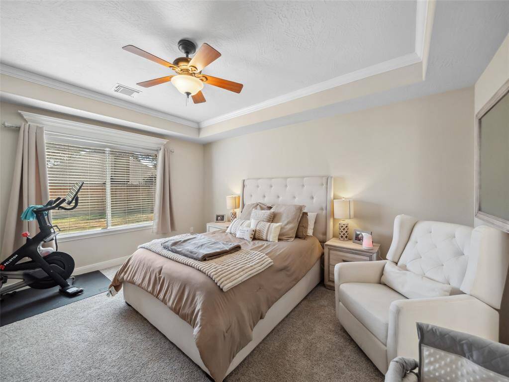 The primary bedroom also features the cove ceiling with crown molding and large window overlooking the back yard. Notice the detailed trim above the window for an added custom look.