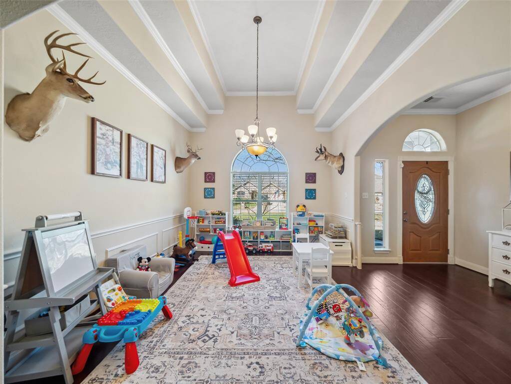 Lovely formal dining room with ceiling detail and large window overlooking the front yard. Crown molding and wainscoting trim add a custom touch to this home.