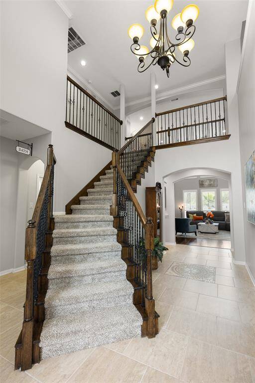 Before we enter the heart of the home, take another look at this grand Foyer. Notice the soaring 18’ ceiling with crown molding, 20’ square tile floors, decorative tile inlay, arched casement openings and oil rubbed bronze chandelier. Upstairs you will find 3 secondary Bedrooms and a Game Room.
