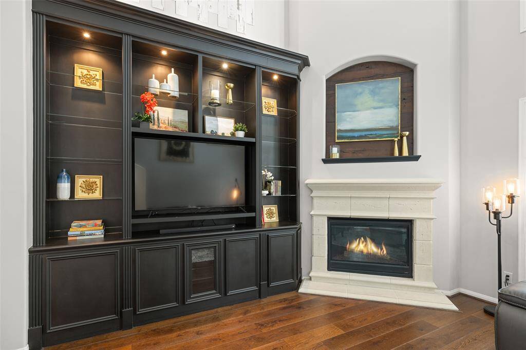 The WOW feature in the Den is this Sherwin Williams painted Tricor Black built-in with adjustable glass shelves, cabinet storage and accent lighting. The large 59” opening will accommodate larger tv’s. The art niche above the fireplace makes a statement with its beautiful wood inlay which matches the rich wood flooring.
