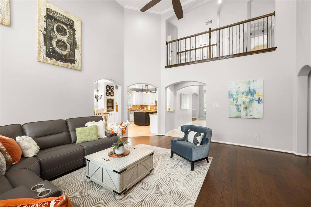Standing in the Den looking back toward the front of the home, you see the Foyer, upstairs landing and Kitchen. The arched casement openings throughout the home provide architectural charm and are wide to accommodate easy entertaining.