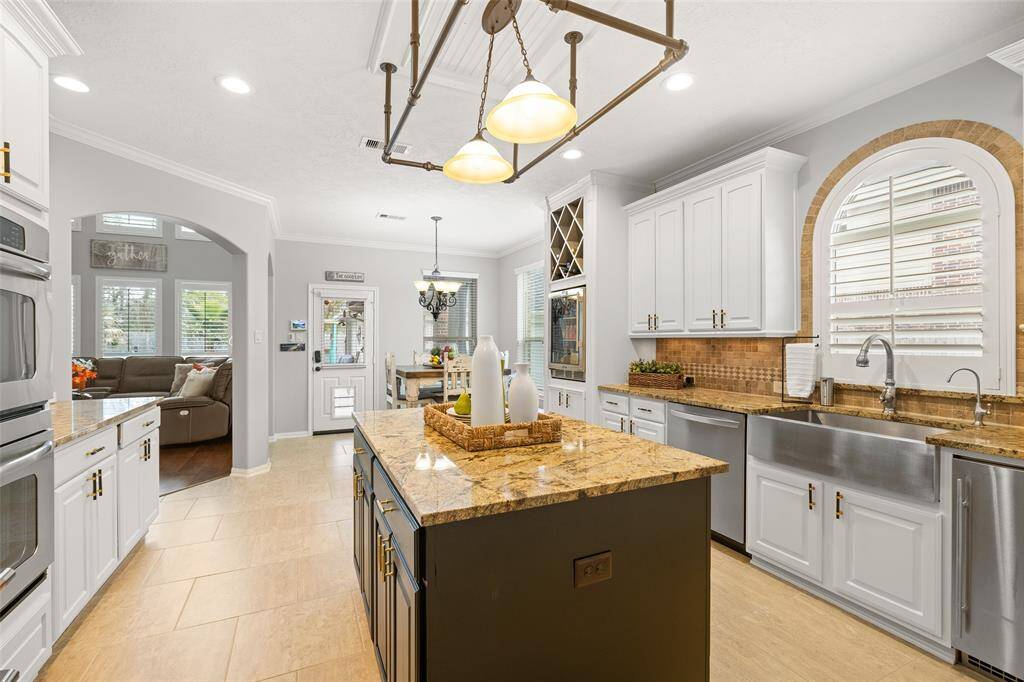 This view of the Kitchen looks toward the Den, Breakfast Room and back entrance (with dog-door) which leads to a covered Patio and outdoor oasis with Tiki Bar and sparkling pool.