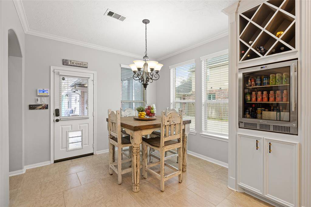 The Breakfast Room offers high 9’ ceilings with crown molding, 20’ tile floors, a dog door and 3 windows providing plenty of natural light. The built-in beverage center is conveniently close for easy entertaining and is elevated to a "comfort-height" which is a feature you will never want to live without again!
