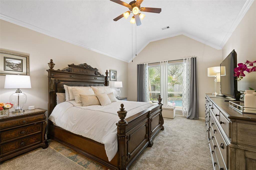 The Primary Bedroom is HUGE, measuring 19’ x 13’. As shown here, this private retreat will accommodate a king-sized bed, 2 bedside tables, two dressers and a seating area overlooking the gorgeous pool. Crown molding, 12' high ceilings, double windows and a secure keyless entry complete this space.