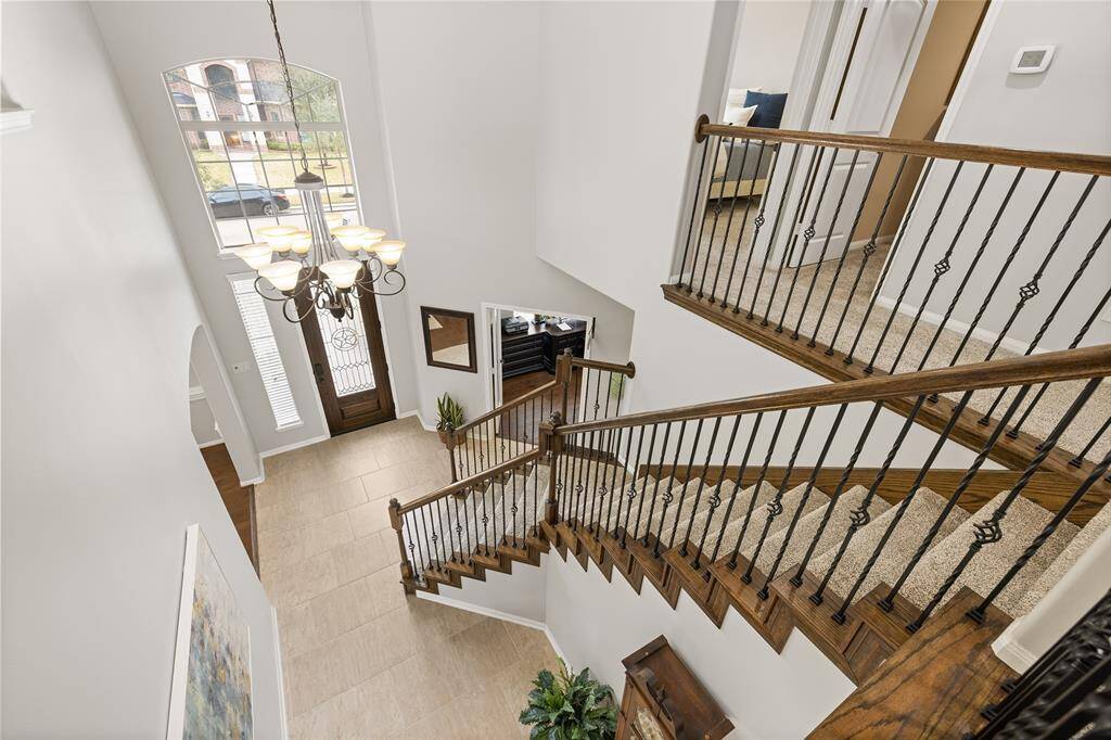 The upstairs Landing provides a panoramic view of the grand Foyer, gorgeous chandelier, and rich features such as the wood and iron staircase.