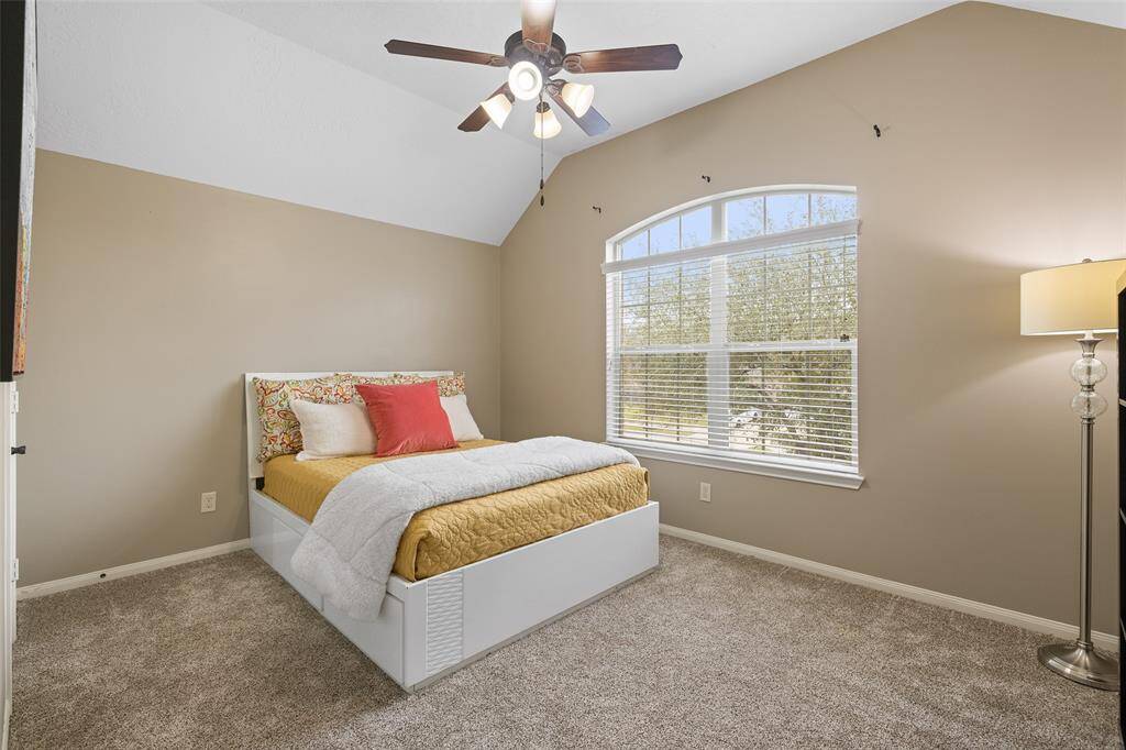Secondary Bedroom #2 measures 15’ x 11’ with a 10’ high vaulted ceiling, ceiling fan, walk-in closet, carpet and double arched windows with front yard views.