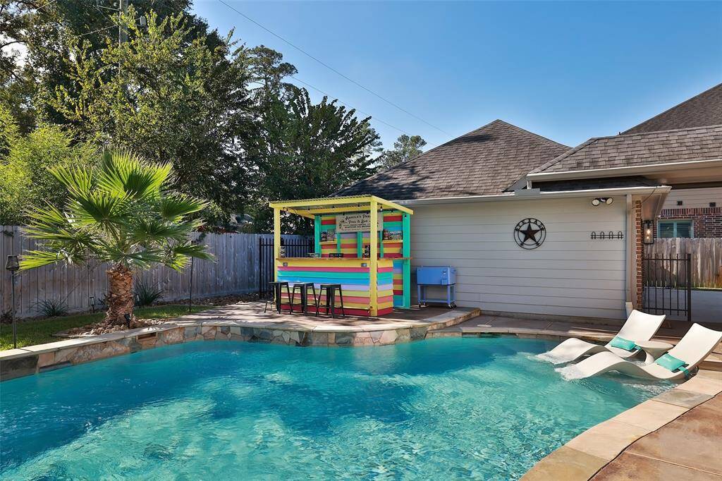 The neighboring lot provides a green, wooded backdrop to your outdoor space. The trees provide natural beauty, privacy and afternoon shade. The pool itself has a flagstone tile surround with a matching stained concrete pool deck.