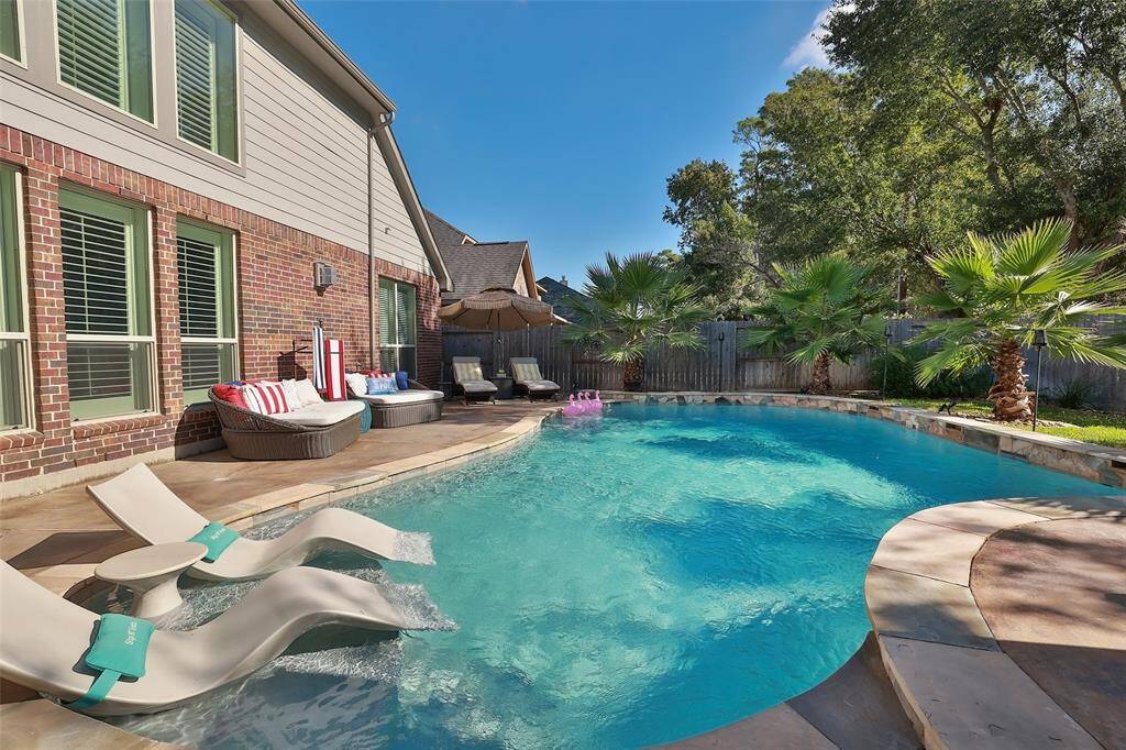 Whether you swim laps, play water volleyball or simply tan on the beach ledge, you are guaranteed to enjoy this backyard oasis. The 2 loungers, patio furniture and flock of flamingos are excluded.
