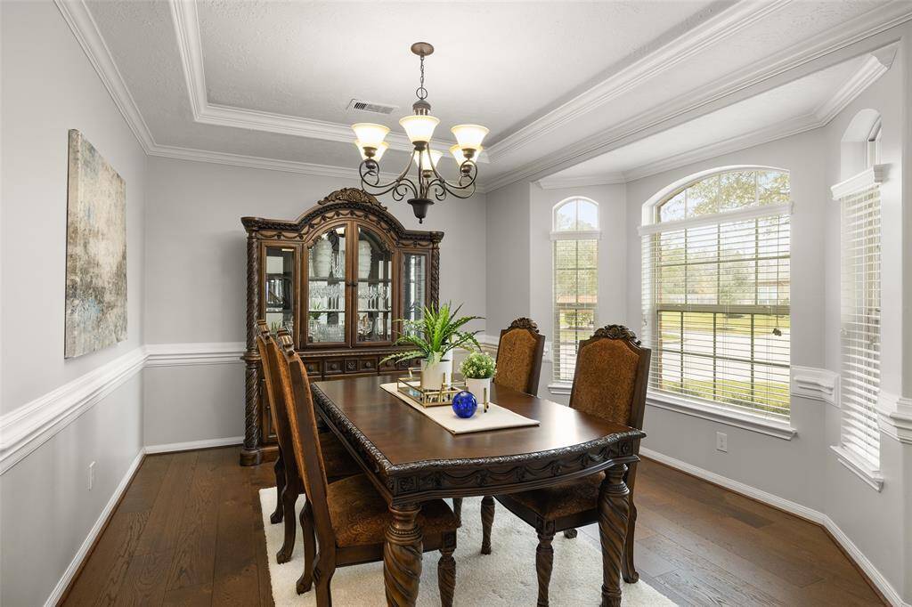 To the right of the Foyer is your formal Dining Room. This spacious and bright room features double chair railing, crown molding, tray ceiling with lighting and bay-style windows with arches and a lovely view of the front yard and cul-de-sac.