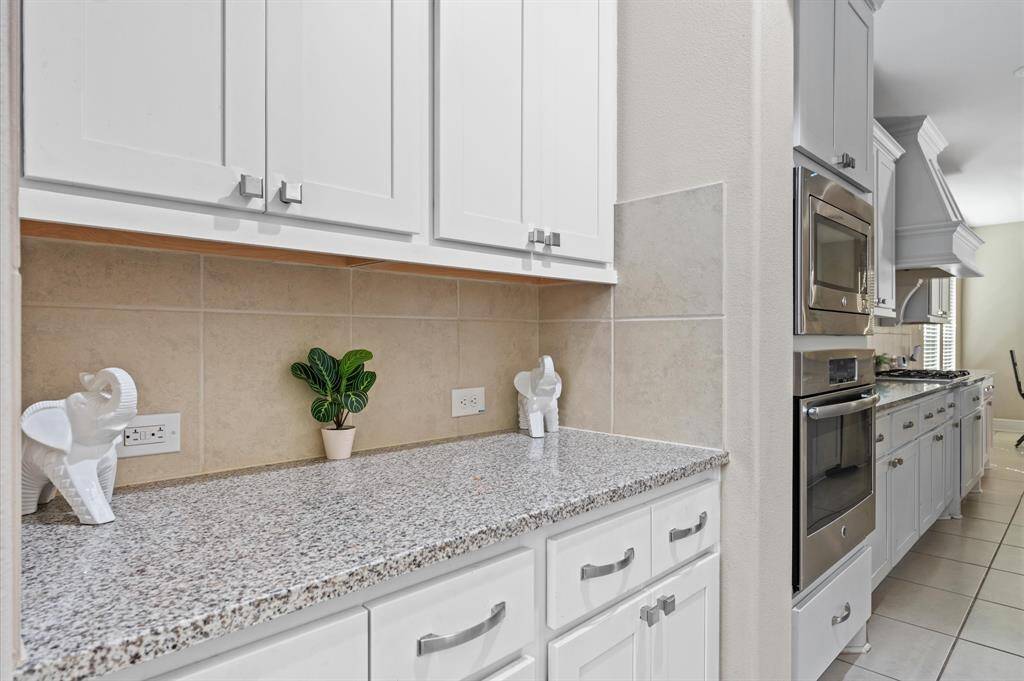 This island is the heart of the kitchen, providing a versatile space for meal prep, dining, and socializing. Well-lit with pendant lighting.
