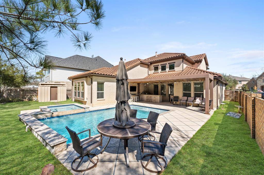 The outdoor kitchen features a spacious granite countertop, beverage fridge, keeping your favorite drinks chilled and easily accessible, gas grill and sink.