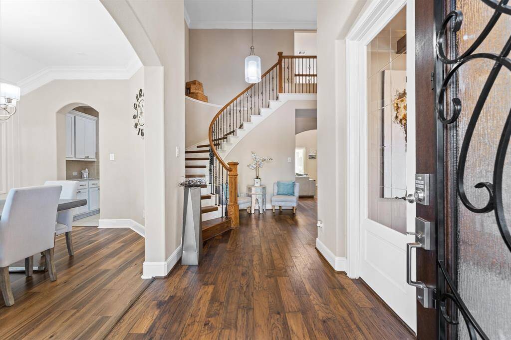 Welcome to anyone who enters this foyer with a spiral staircase as a striking centerpiece.