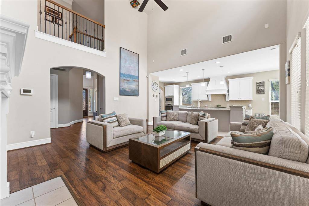 Step into this two-story living room that exudes elegance and openness. The large windows flood the space with natural light and offer breathtaking views of the backyard oasis.
