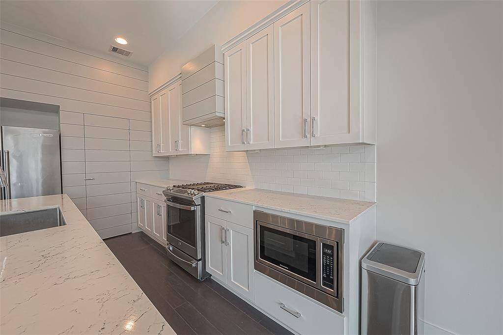 Marble Countertops, kitchen island with an abundance of cooking space, gas stove and built in microwave