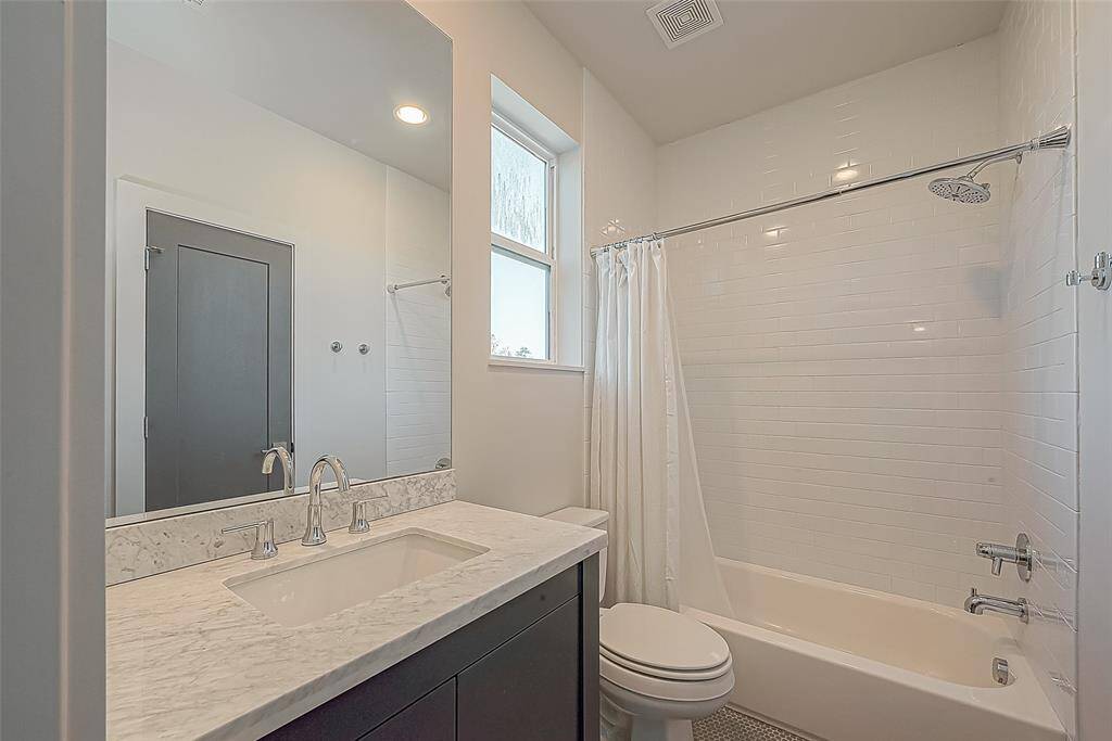 Ensuited secondary bathroom with gorgeous countertops and a closet.