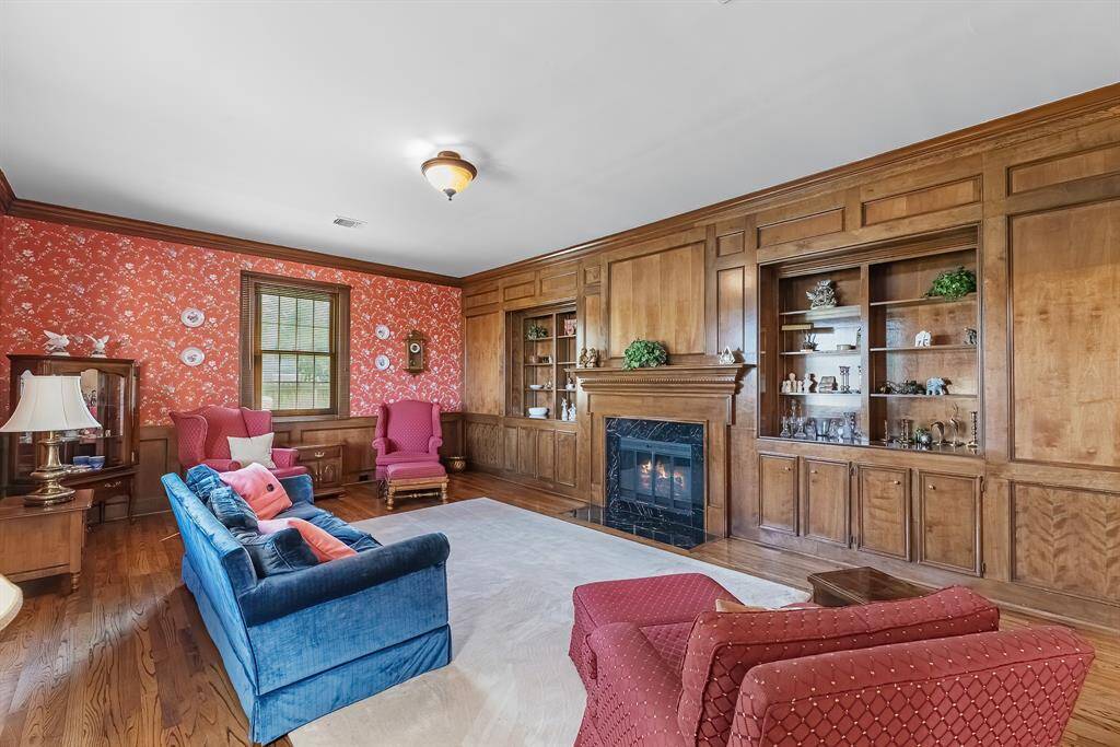 The den features hardwood floors and custom built in shelving. A very cozy place to sit around the fireplace on a chilly evening or to read a novel.