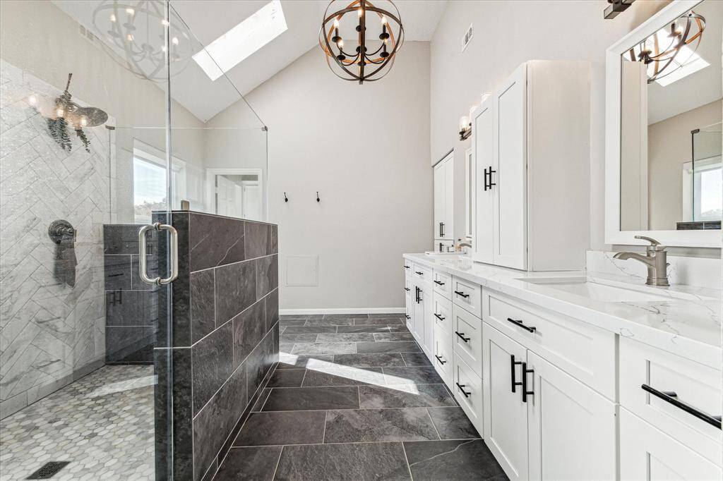 The primary bath boasts dual sinks, a spacious shower with two shower heads and a private water closet.