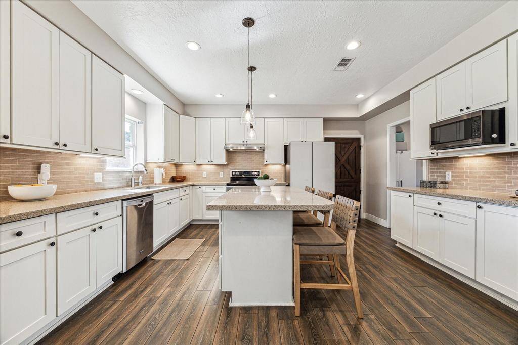 Discover the elegance of a fully remodeled kitchen with sleek granite countertops, modern stainless steel appliances and inviting counter seating.