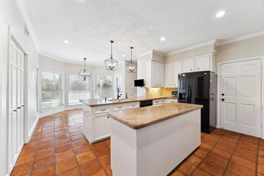 The island kitchen has a breakfast bar that flows seamlessly into the eating area.