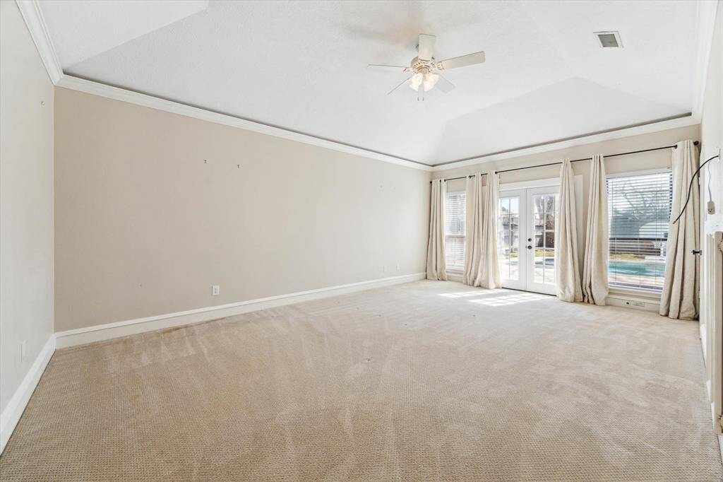 The primary bedroom is located on the ground floor and provides a private retreat separate from the other bedrooms. It has a coved ceiling, ceiling fan and French doors to the fabulous back yard.