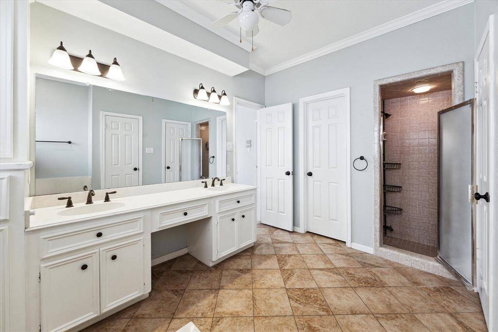 The separate shower is tiled all the way to the ceiling.