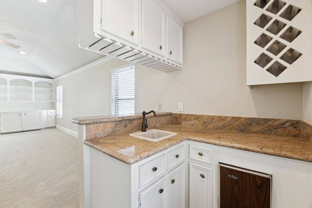 The wet bar has a sink, ice maker, and wine and glass racks. Perfect for entertaining.