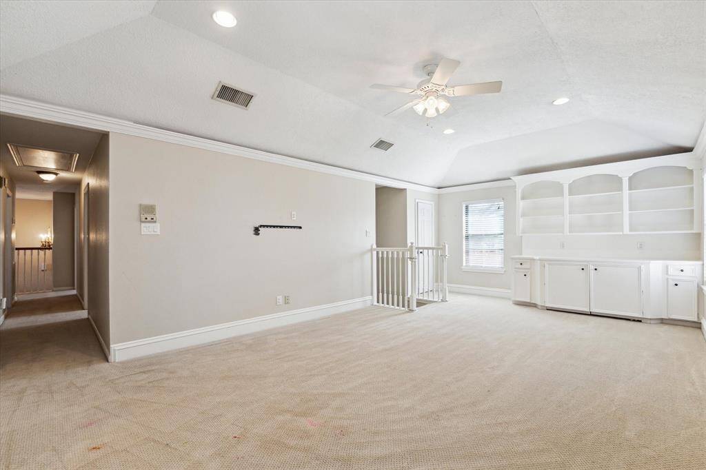 Coved ceiling, ceiling fan, built-ins and stairs down to the kitchen make this a wonderful and handy retreat.