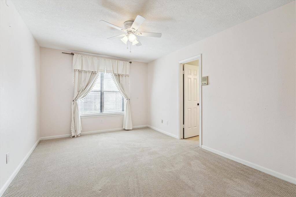 Bedroom at the top of the stairs overlooks back yard and incorporates ceiling fan and cedar closet