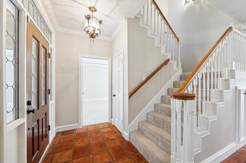 The gracious entry is through the leaded glass door surrounded by glass transoms to a beautiful tile floor and an elegant staircase leading up to the second story.