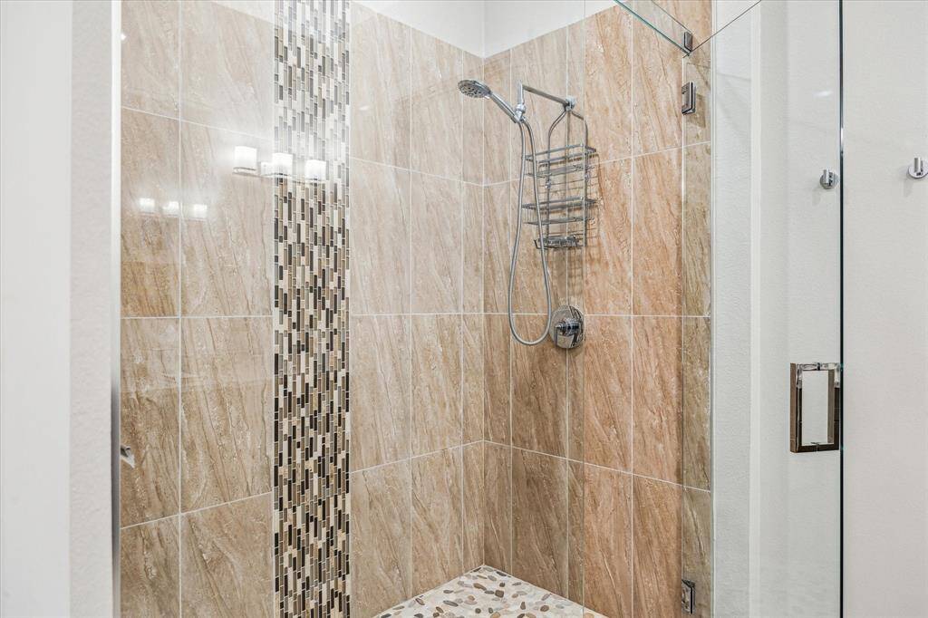 Unwind at night in the large tiled shower with rounded stone floor.