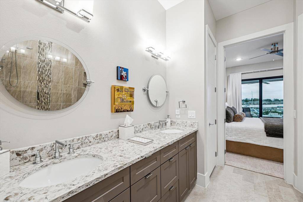 Double vanity with decorative mirrors, granite countertops and custom lights.