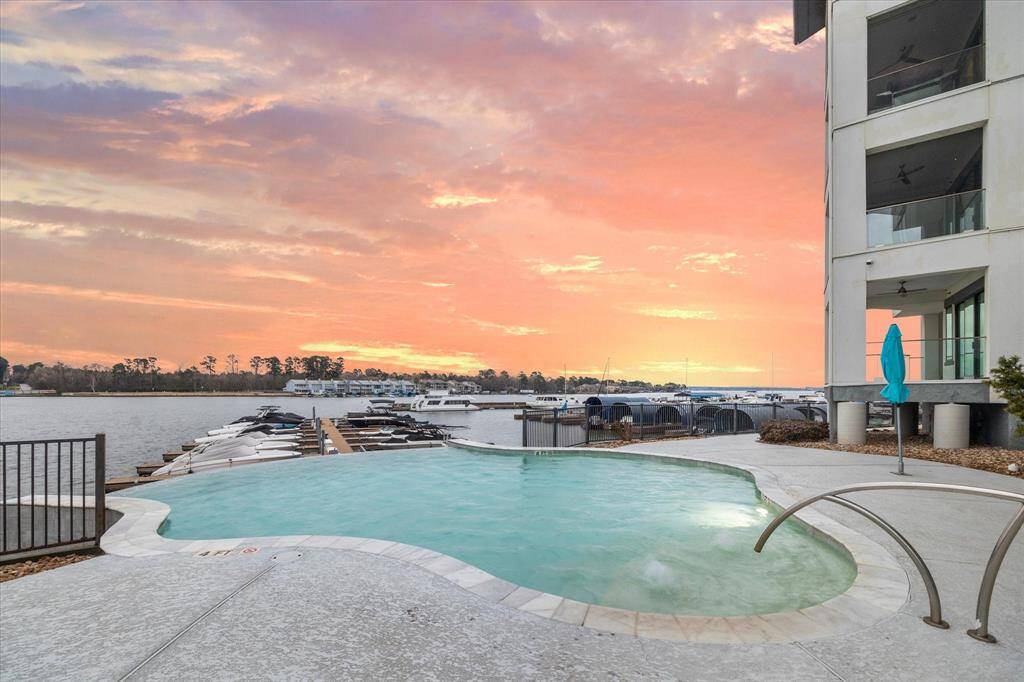 Envision yourself floating in a sleek infinity pool, seamlessly blending with the horizon, as you gaze out over a tranquil lake, where the water's edge seems to stretch into infinity.