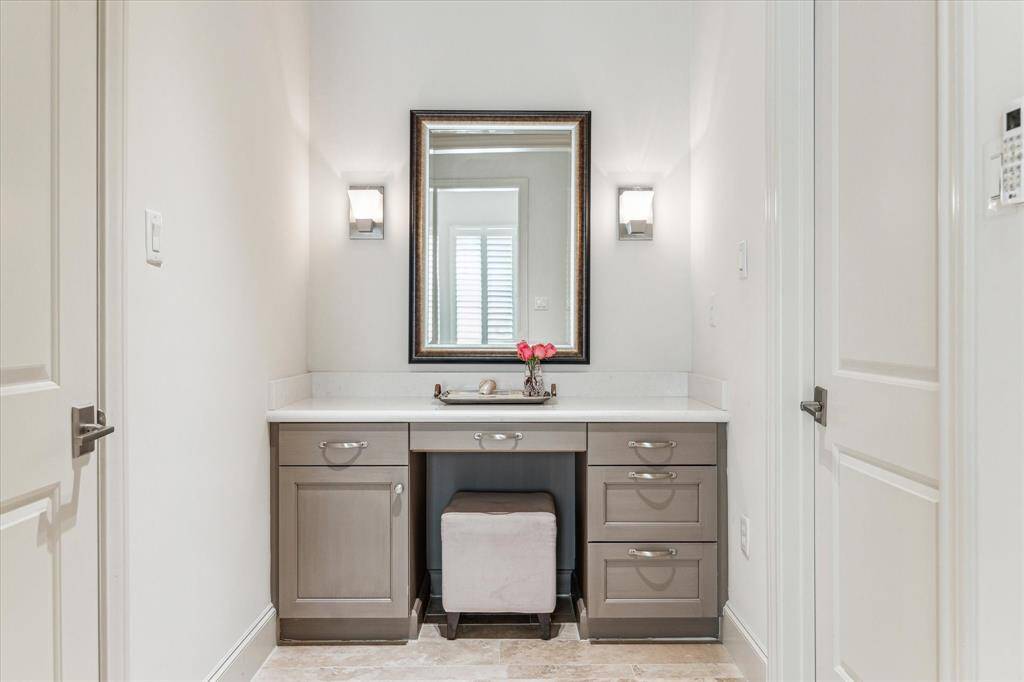 This pretty, quartz-topped vanity is near the two walk-in closets in the primary bath.