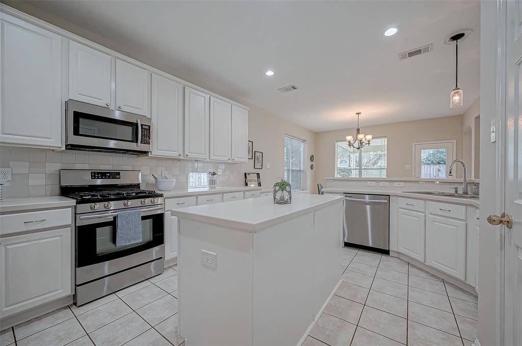This beautifully designed kitchen boasts abundant storage, a spacious island, and plenty of natural light, creating a warm and inviting space where style meets functionality.