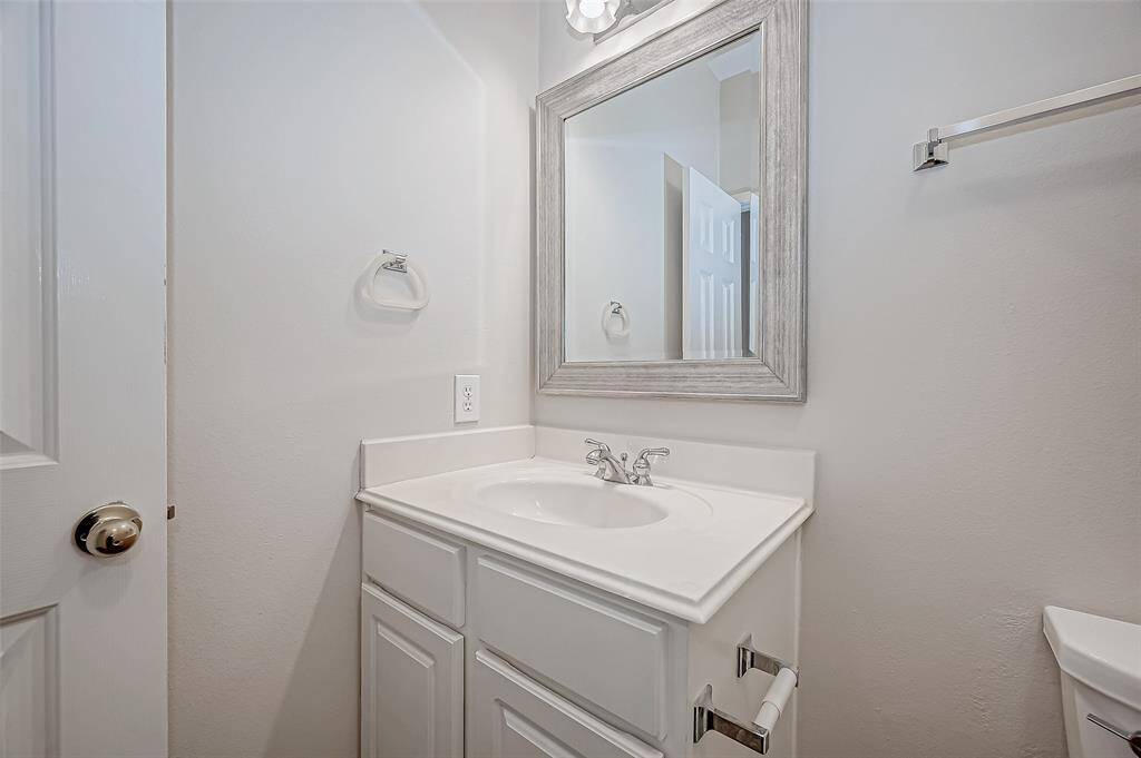 This charming half-bathroom offers a fresh and stylish touch, perfect for guests and everyday convenience. The crisp white vanity, sleek fixtures, and elegant framed mirror create a bright and inviting space. Tucked away for privacy yet easily accessible, this powder room adds both function and charm to your home.