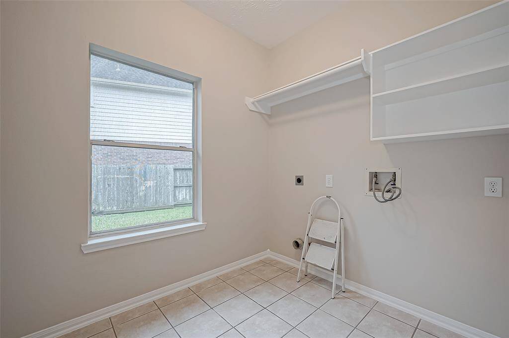 Laundry day just got better with this bright and spacious utility room, complete with built-in shelving and a large window that fills the space with natural light. With plenty of storage and room to move, you’ll have an efficient and organized space to tackle chores with ease!
