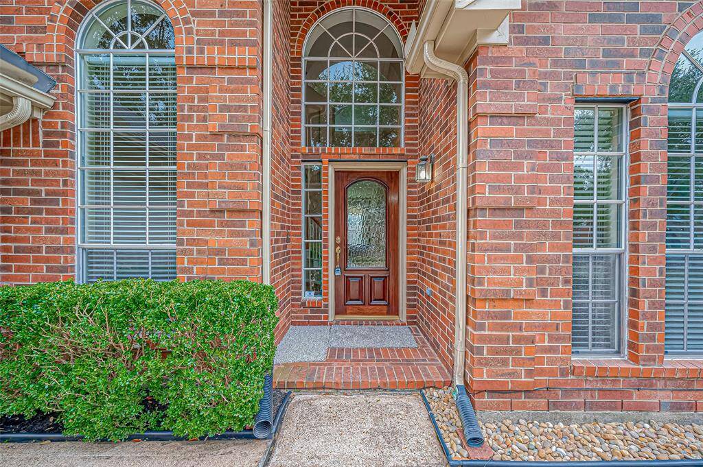 Step up to this inviting entryway, where a gorgeous glass-paneled front door allows natural light to pour into the home, creating a warm and welcoming first impression. A beautifully designed walkway adds a touch of sophistication, offering both durability and curb appeal to this stunning home.