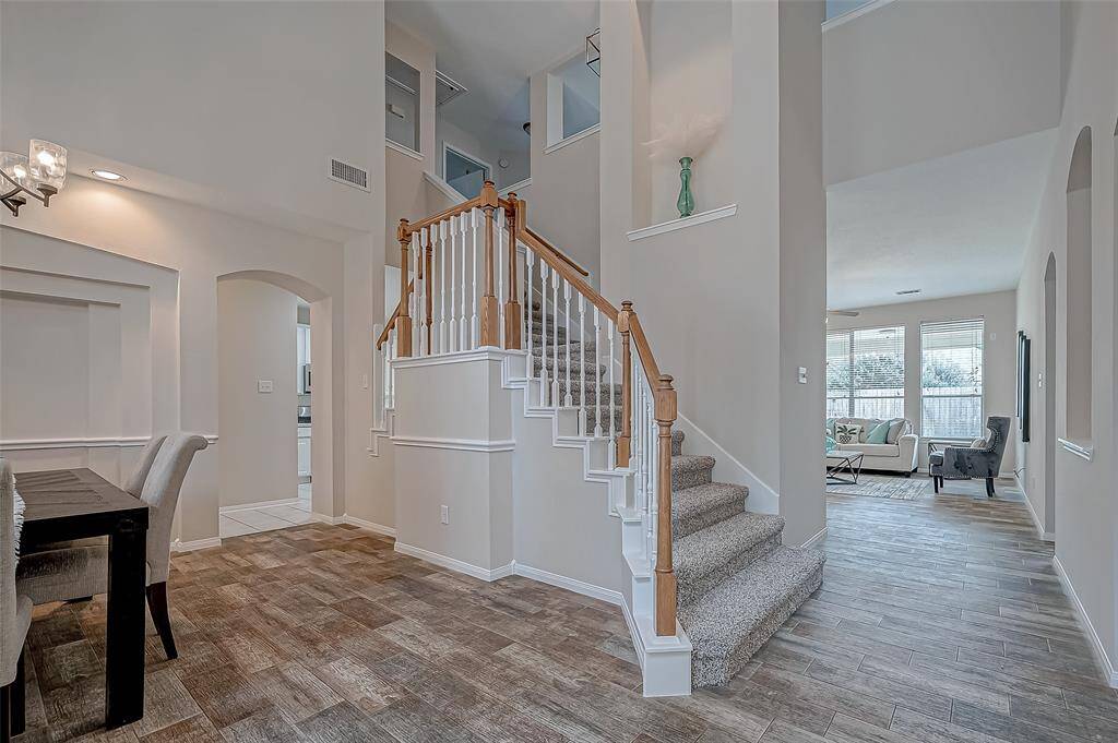 As you step into the home, your eyes are immediately drawn to this beautifully designed staircase, serving as both a stunning focal point and a seamless path to the second floor. Conveniently positioned between the dining area and the open living space, it allows you to move effortlessly upstairs while still feeling connected to the warmth and flow of the main living areas.