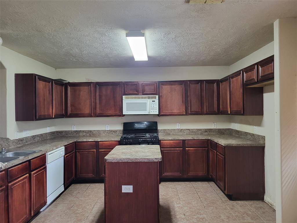 Beautiful large spacious kitchen displaying large island, lots of cabinets, dishwasher and microwave.Plenty of room to cook and entertain to create many memories.
