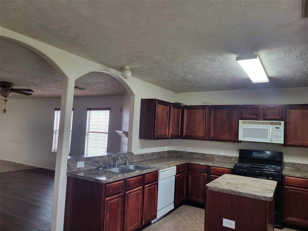 Kitchen displaying arches and appliances, stainless steel sinks.