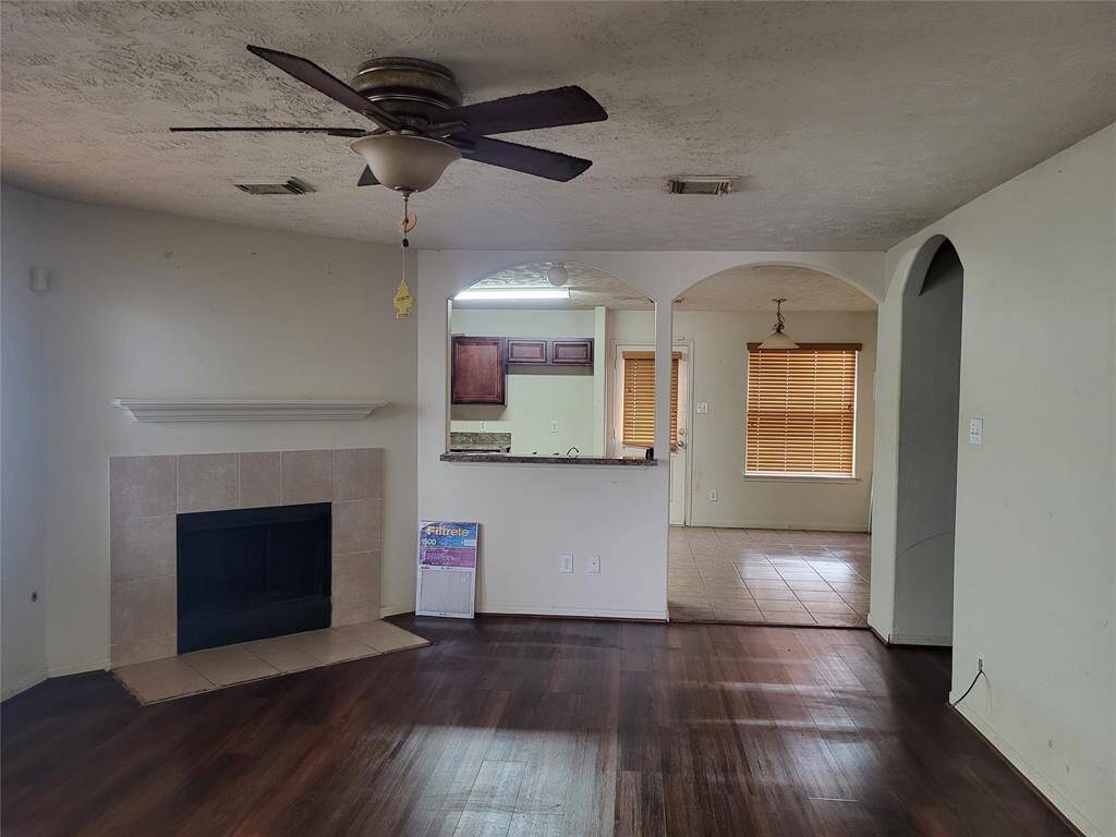 Inviting fireplace displaying beautiful arches displaying a bar and a perfect view into the kitchen