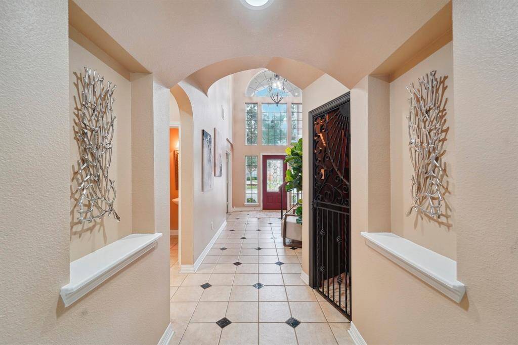 It will be love at first sight! This home is filled with elegant features from front to back, including a charming wine grotto, beautiful tile flooring, graceful arched doorways, art niches, and soaring ceilings with chic lighting and fans.