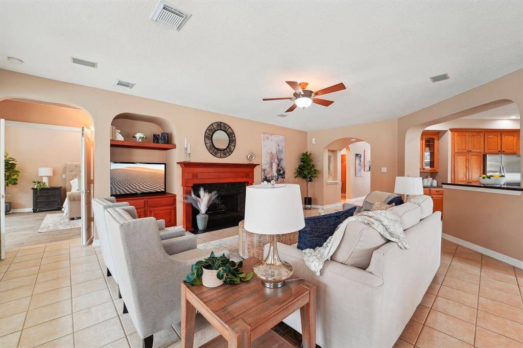 The spacious family room easily accommodates oversized furnishings, providing a welcoming and comfortable space for gathering and relaxation. A captivating gas-log fireplace serves as the focal point, complemented by a built-in niche ideal for a TV and additional storage.