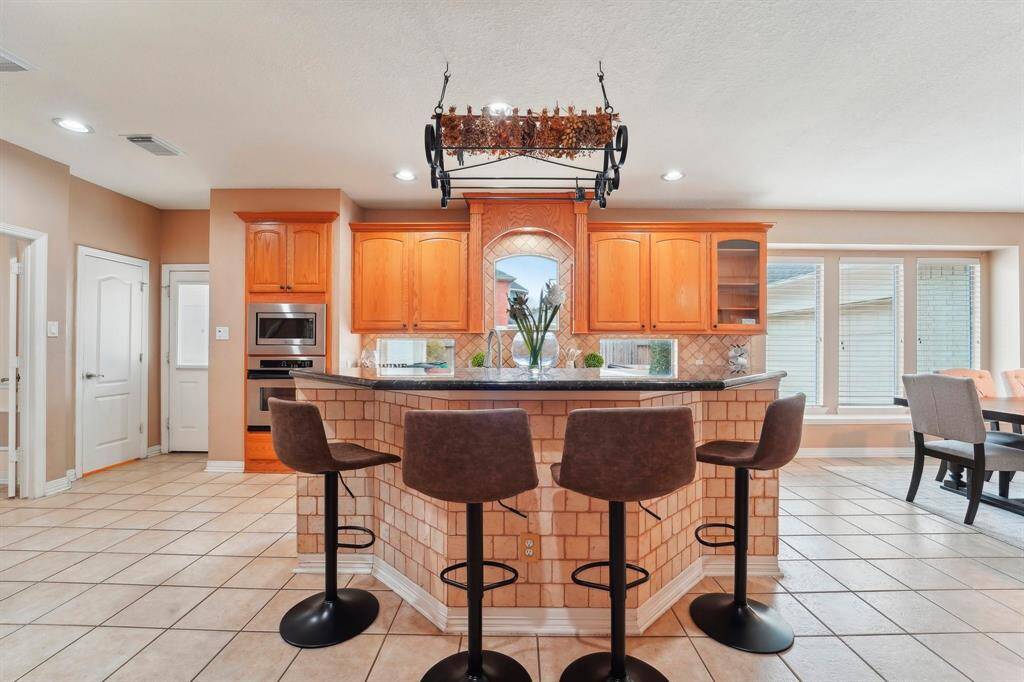 This amazing open floor plan allows you to easily mingle with guests. An oversized bar separates the kitchen from the family room. This is a great feature for serving drinks and snacks or add barstools to create additional seating.