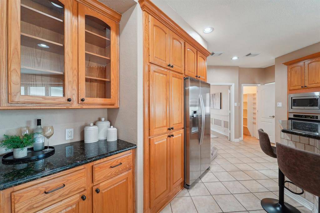 An abundance of cabinets, drawers, plus a spacious walk-in pantry provide ample storage for all your favorite kitchen gadgets. Take note of the impressive floor-to-ceiling cabinetry and the massive walk-in pantry, ensuring everything has its place while keeping your kitchen beautifully organized.