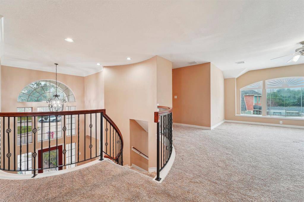 A split staircase from the foyer and kitchen leads upstairs to a large game room, , four spacious bedrooms, and two full bathrooms—offering plenty of room for relaxation and entertainment.